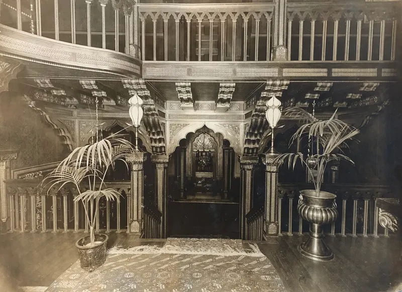 Archival interior photograph of the ornate carved hall and balcony
